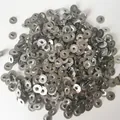 Bulk metal eyelets for candle wicks piled on a white background for DIY candle making - 100pcs Candle Wick Tabs (12.5mm)