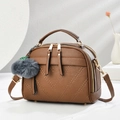 Brown lychee leather crossbody bag with V-stitching and a grey plush pompom charm - Earthy Yellow