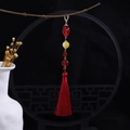 Detailed view of red tassel pendant with pearls hanging on a wooden branch - Red Long Tassel Beaded Pendant Style (E6502)