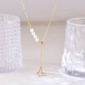 Golden necklace with white shell butterfly pendant and elegant pearl accents on a fine chain - Butterfly Style