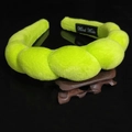 Macro detail of handmade braided neon green plush headband on a dark wooden display stand - Twisted Sponge Headband / Fruit Green