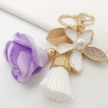 Detailansicht Schlüsselanhänger mit lila Stoffrose, Strass-Quaste und Emaille-Blüte - Lila