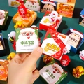 Handheld view of Christmas tumbler blind boxes with Santa and Snowman cartoons - Christmas Blind Box Roly-poly Toy / Price Per Box
