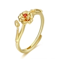 Detalle macro del anillo de flor dorada ajustable con piedra de circón rojo y rama - Enero