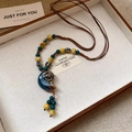 Dettaglio macro del ciondolo a conchiglia nautilus e perline vintage in ceramica - Stile Nautilus Blu (7# Collana-Blu)