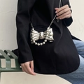 Silver bow-shaped metallic handbag with bead accents and chain strap on model - Silver Style 3 (Beaded Decor)