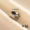 Detail view of silver ring with oval black stone inlay and solar ray texture engraving - Silver-Black Enamel