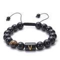Detail of hand-woven black agate bead bracelet featuring a golden letter V charm and tiger eye - Letter V