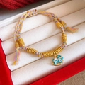 Detail of colorful braided bracelet with golden beads and an enamel pony charm - Colored Rope Enamel Pony - Gold - Yellow - Green