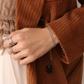Silver interlocking chain bracelet with matching rings on a model in vintage style - Steel Interlocking Geometric Bracelet