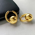 Macro shot of French luxury polished brass hoop earrings with metallic gold bead charm - Hoop Ball Style (A0421B) / Gold