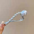 Gedetailleerd macro-beeld van een zilverkleurige haarklem met witte parels - Twist Clip / Zilver