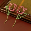 Macro detail of tulip flower earrings with pink and green crystals on vintage wood - Pink and Green (Gold Base Silver Needle)