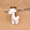 Detail of white PU leather giraffe keychain with gold chain and sparkling crystal charm - White