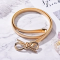 Ceinture élastique en métal doré avec boucle nœud élégante sur fond de marbre - Nœud papillon / Doré