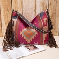 Close-up of bohemian woven tote bag showing tribal patterns and long side fringes - Fuschia