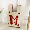 Close-up of knit tote bag with red butterfly patterns and star embroidery details - Beige Butterfly Bag