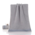 Thick dark grey pure cotton towel with blue striped border and soft terry texture - Gift Grey
