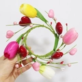 Handheld view of a colorful artificial tulip and heart bead candle ring with green leaves - Tulip Heart Valentine Candle Ring