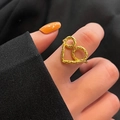 Eleganter goldener Vintage-Herzring mit hohler Textur am Finger des Models getragen - Hohlherz-Textur-Stil (TJZ327)