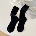 Chaussettes noires classiques en coton avec revers côtelés sur un fond blanc épuré - Taille unique / Noir