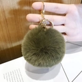 Olive green faux fur heart keychain with golden ring and lobster clasp on hand - Small Army Green Pom Pom