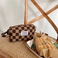 Close-up of brown corduroy checkered makeup bag with woven handle and side logo - Dark Brown Checkerboard