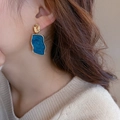Gros plan d'un modèle portant des boucles d'oreilles en résine marbrée bleue et or - Géométrique en Marbre Bleu (47#)