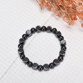 Bracciale minimalista in ematite con perline nere sfaccettate su sfondo a griglia bianca - Perlina Rotonda 8mm + Sfaccettata