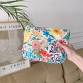 Close-up of floral print fabric makeup bag featuring the Sozakka woven brand label - Spring Garden Floral