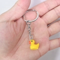 Cute yellow resin duck keychain pendant with silver metal ring held in hand - 28mm Ring / Yellow