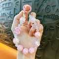 Pink bow crystal beaded phone strap with iridescent beads and a dollar sign charm. - Pink