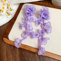 Detail of long purple earrings with chiffon petals and beaded tassels on a wood tray - Purple Flower (11# Silver Pin)
