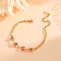 Dettaglio di un bracciale in acciaio placcato oro 18k con gemme tonde viola - Braccialetto Viola (K106)