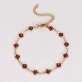 Detail of a gold stainless steel bracelet with square reddish-brown glitter resin inlays - Red
