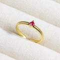 Close-up of golden open ring featuring horizontal texture and a red ruby-colored gemstone - Red Stone Textured Band (款式3)