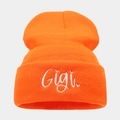Detailed close-up of Gigi cursive embroidery on orange knitted beanie texture - One Size / Orange Red