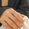 Dettaglio anello incrociato argento con zirconi colorati indossato sulla mano - Zirconia multicolore intrecciata argento