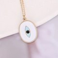 Detailed close-up of golden evil eye pendant with blue enamel on purple silk fabric - Oval Beaded Edge Blue Evil Eye Style (2#)