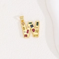 Macro shot of gold letter W pendant featuring colorful cubic zirconia stones and zircon inlay - Letter W