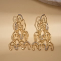 Detailed close-up of gold geometric twisted wavy earrings with sparkling rhinestones - Gold