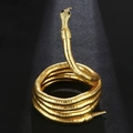 Detailed close-up of golden snake bracelet with intricate scale texture and black gem eyes - Engraved Gold