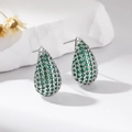 Silver teardrop earrings with green cubic zirconia set on minimalist white stone background - Green