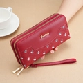 Detail of red embossed long wallet with double zippers, flower pattern and wrist strap - Red