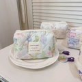 Dettaglio della borsa da trucco in cotone trapuntato su un piatto di ceramica - Pittura a olio floreale rosa verde