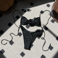 Detailed flat lay of black bikini set featuring 3D rose accents and thin straps - Black with Black Flower