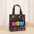 Detail van een zwarte vlies-cadeautas met kleurrijke WOW-letters en sterpatronen - Wow Pop Art