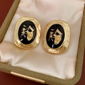 Detailed close-up of vintage gold oval earrings with black enamel and carriage relief - Alloy with Silver Pin / Vintage Carriage Oval Style / Gold Black