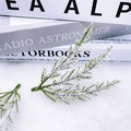 Detail of snowy PE pine needles with white flocking on a minimalist textured background - Snowy 10cm Three-prong Pine Needle / Snowy Green