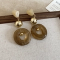 Detail of irregular acrylic earrings with gold metal accents on textured fabric - Beige Brown Earrings (Silver Pin)